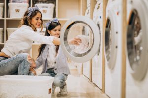 mother with daughter doing laundry self serviece laundrette 1303 19547